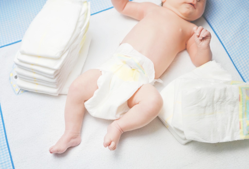 feet-of-newborn-baby-on-changing-table-with-diapers-cute-little-girl-picture-id1304183897 תינוק על משטח החתלה