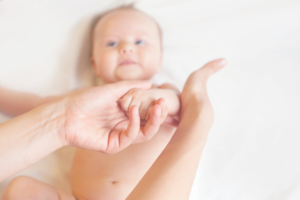 mother-makes-baby-massage-with-happy-newborn-at-white-bed-picture-id485469752 אוסטאופתיה לתינוקות